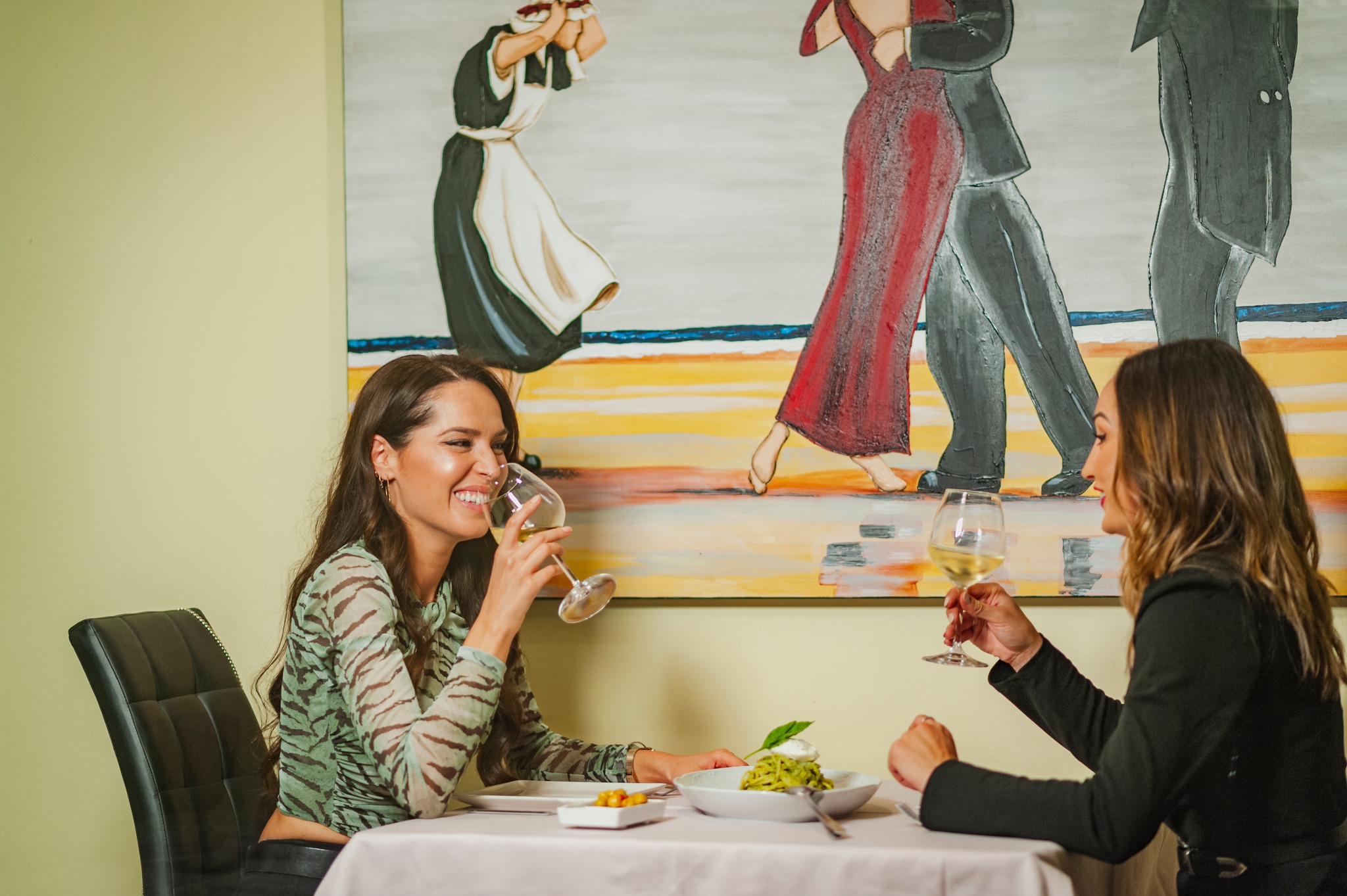 Sapore Italia mujeres sonrientes sentadas en mesa con copas de vino