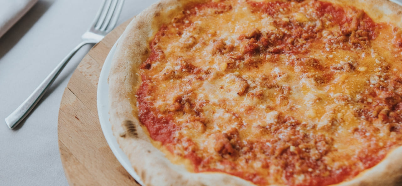 Sapore Italia detalle de pizza de queso con tenedor al lado